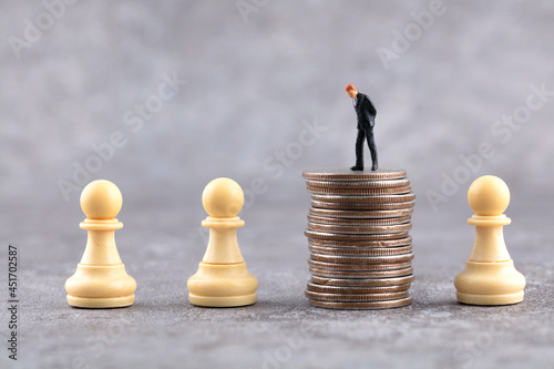 Chess figures and coins and business figures