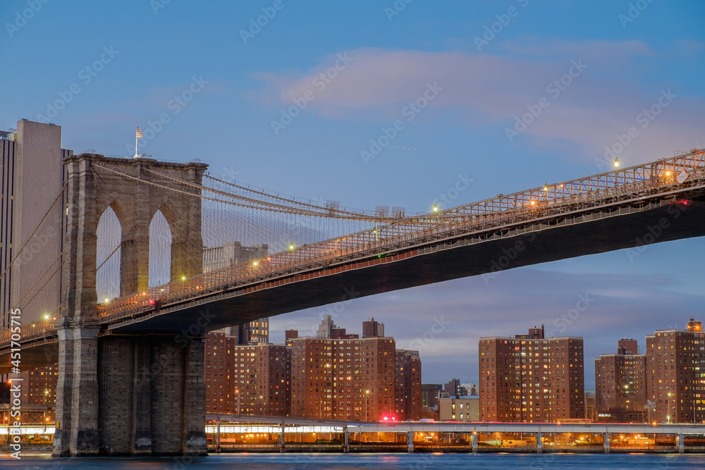 Fototapeta premium Brooklyn Bridge spanning the East River from Brooklyn into New York City at sundown