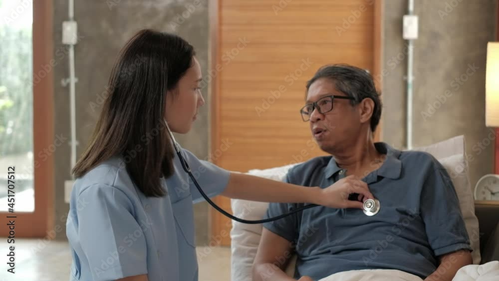 Female doctor checking the health of Asian elderly male patient at home as a medical service for visiting sick older people after retirement, medical support, residential caregiver from professional. Female doctor checking the health of Asian elderly male patient at home as a medical service for visiting sick older people after retirement, medical support, residential caregiver from professional.