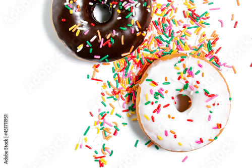 Chocolate, vanilla, and maple frosted donuts with rainbow sprinkles on a white background