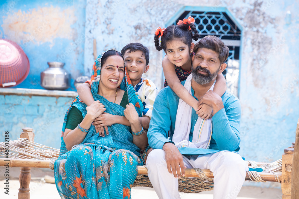 Portrait of happy rural indian family looking at camera while sitting ...