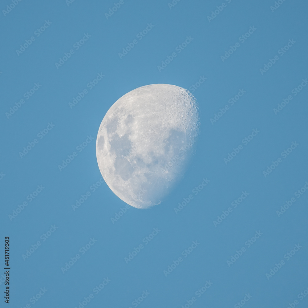 Late afternoon partial moon in the blue sky Late afternoon partial moon in the blue sky