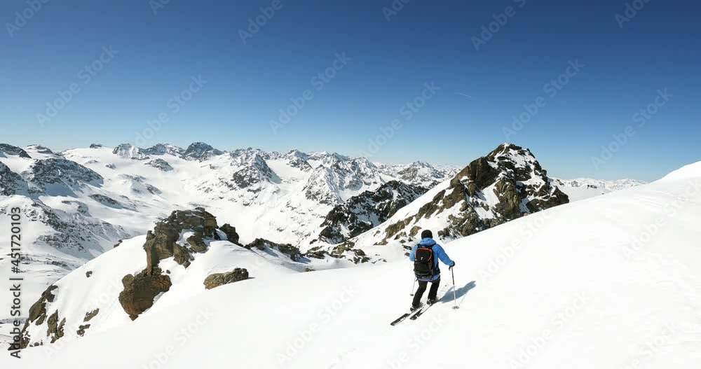 Ski mountain guide skiing spring snow in stunning winter alpine landscape. Follow camera skiing in high alpine terrain with beautiful sun light. Tirol Backcountry spring snow skiing. Ski mountain guide skiing spring snow in stunning winter alpine landscape. Follow camera skiing in high alpine terrain with beautiful sun light. Tirol Backcountry spring snow skiing.