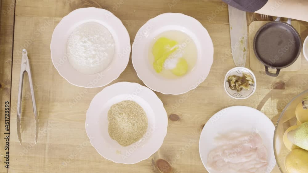Cook sprinkling salt on eggs then stirring them up on a white plate, top view static Cook sprinkling salt on eggs then stirring them up on a white plate, top view static