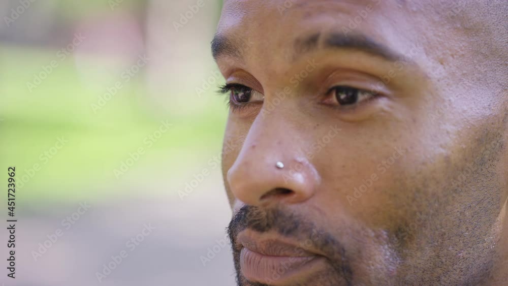Close side shot of young black male in conversation with someone off camera Close side shot of young black male in conversation with someone off camera