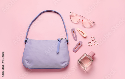 Composition with trendy handbag and different accessories on color background