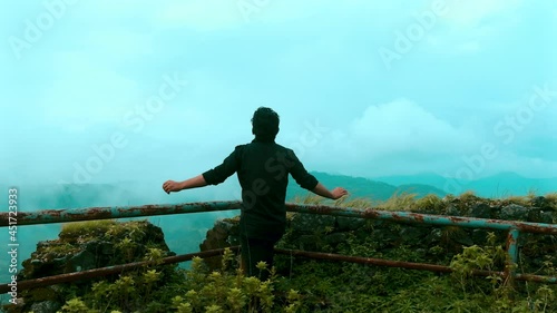 person standing on the edge of the mountain