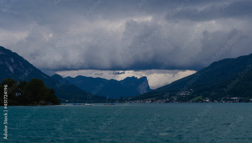 Lake attersee at storm cloudy sky with alps mountain. Moody weather, Austria, salzburg region.