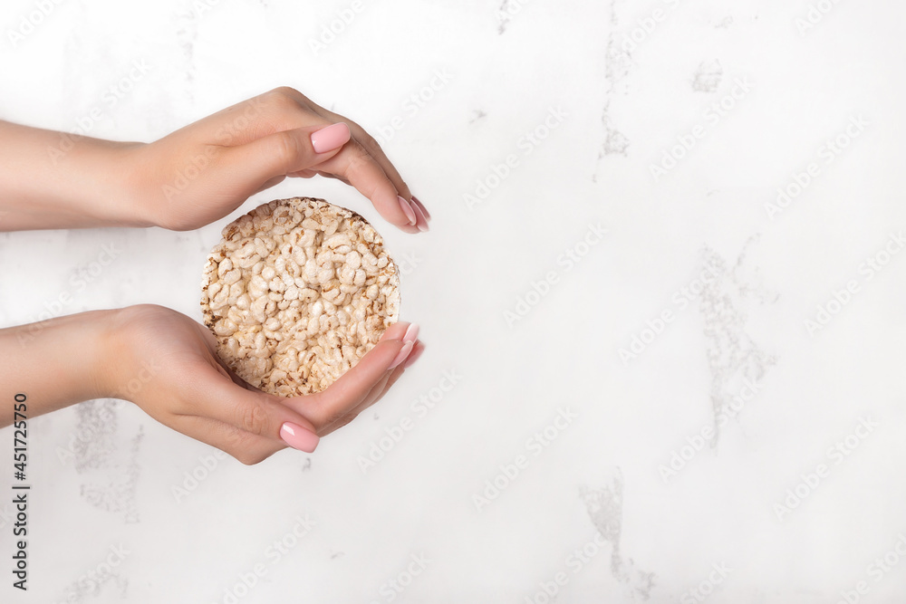 Puffed rice bread in hand, on a white background Puffed rice bread in hand, on a white background
