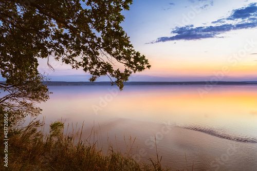 Beautiful gentle sky over the sea during sunset. Pink romantic summer shades of the sky. Sandy beach.