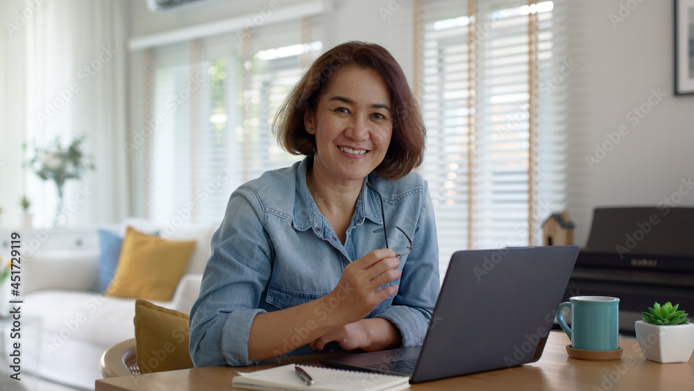 Asia smart people or latin sme owner sit on desk table at home look at camera enjoy read e-mail on digital tablet, smart wireless wifi 5G in money trade, smile happy female typing write search data. Asia smart people or latin sme owner sit on desk table at home look at camera enjoy read e-mail on digital tablet, smart wireless wifi 5G in money trade, smile happy female typing write search data.