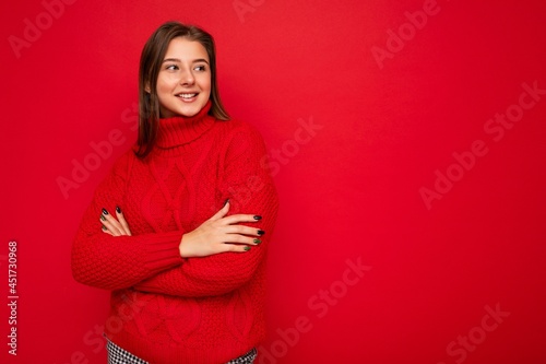 Shot of attractive happy smiling young woman wearing casual outfit standing isolated over colourful background with empty space looking to the side