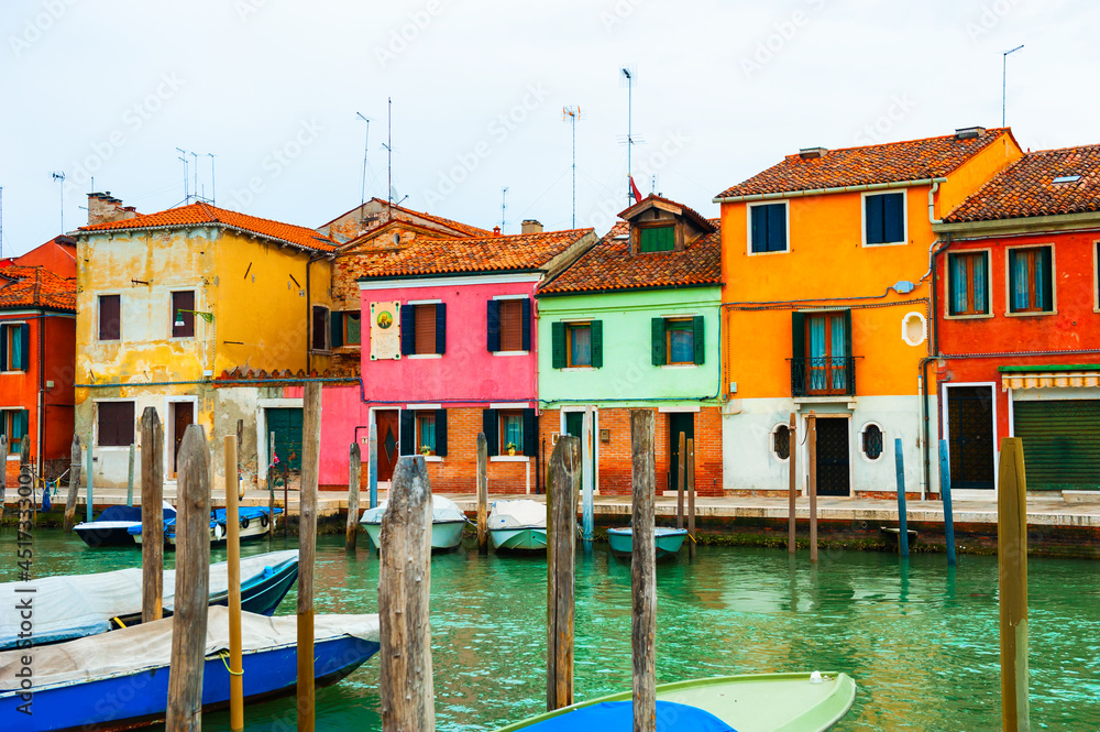 Colorful houses on the canal in Murano island, Venice, Italy. Famous travel destination.
