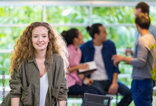 Obraz na plátně Focus foreground smart trendy hipster beautiful casual female leader standing in startup creative modern company, smiling with profession, happiness, confidence and blur background diverse colleagues