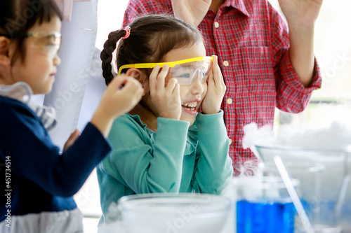 Asian kids happily and curious watching reaction of smoke lab testing in science subject in class with excited and wearing safety eyeglasses