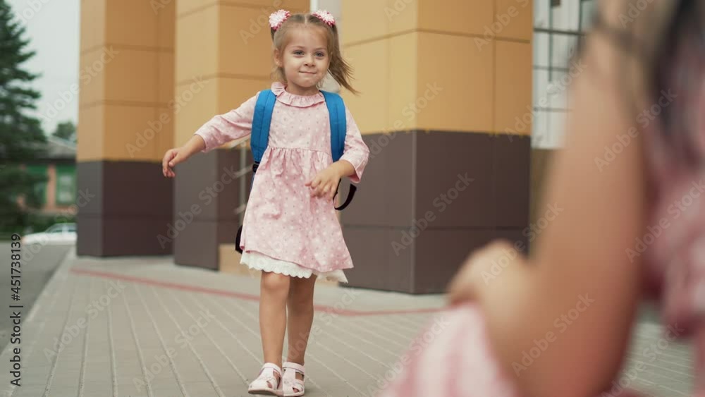 Happy family. Mom meets her daughter from school. Girl with backpack