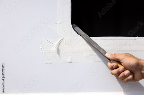 Hand with a file deburring a metal sheet photo