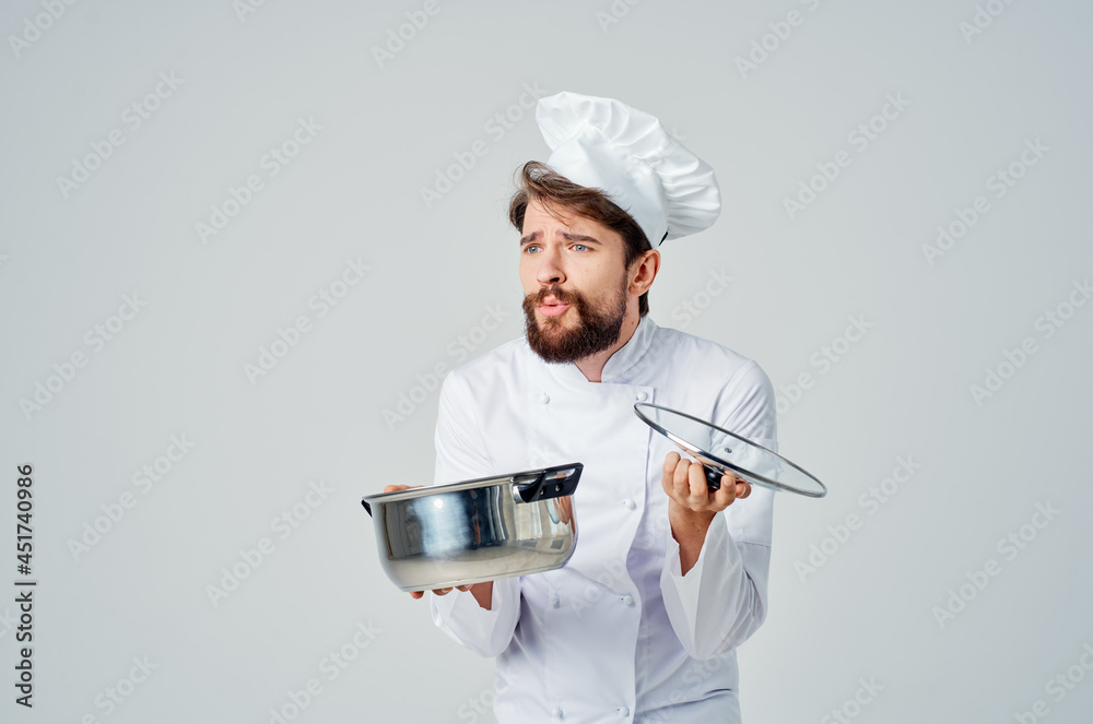 a man in a chef's uniform with a pan in his hands cooking food service a man in a chef's uniform with a pan in his hands cooking food service