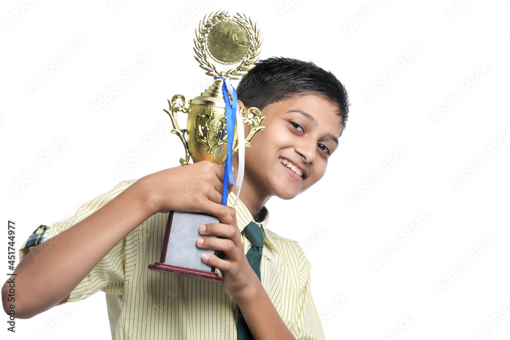 Clever schoolboy raising his trophy as a winner in school competition. Clever schoolboy raising his trophy as a winner in school competition.