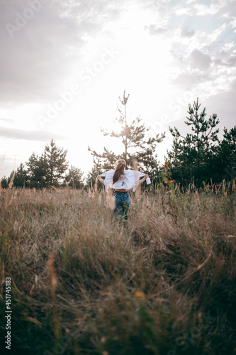 A Free, Happy Woman Enjoying Nature. Pretty Girl Outdoors. The girl runs across the field