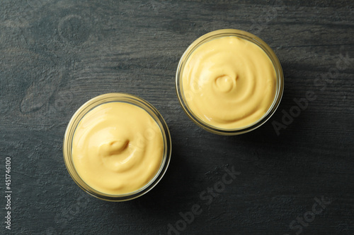 Bowls with cheese sauce on dark background