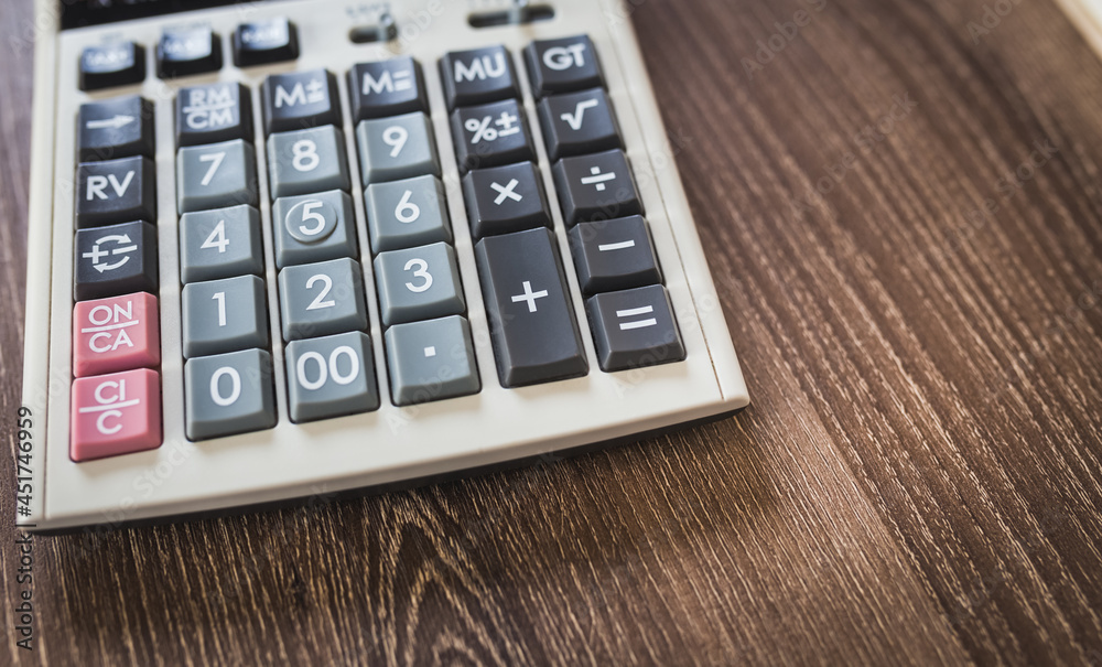part of calculator on wood table background part of calculator on wood table background