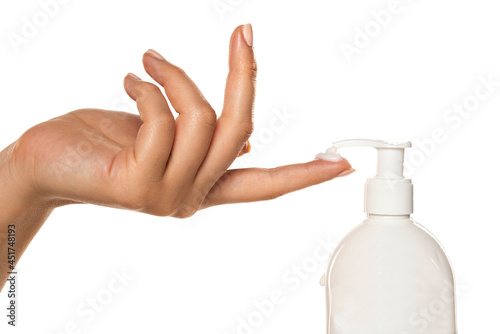 a woman applies a cosmetic product with a pump on her finger