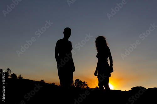 Young couple backlit at sunset. Copy space.