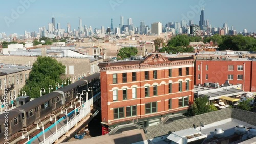 A slow dolly zoom shot of the distant Chicago skyline behind an old motel beside a rail train station.