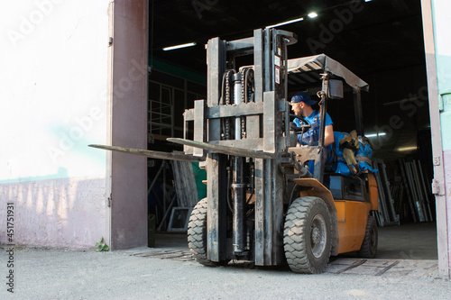 Obraz na plátně Worker driving forklift and loading glass constructions
