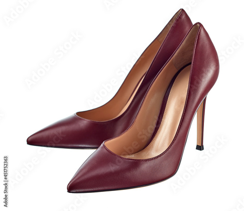 Pair of classic closed women's high-heeled shoes, made of rich burgundy leather, isolated on a white background.