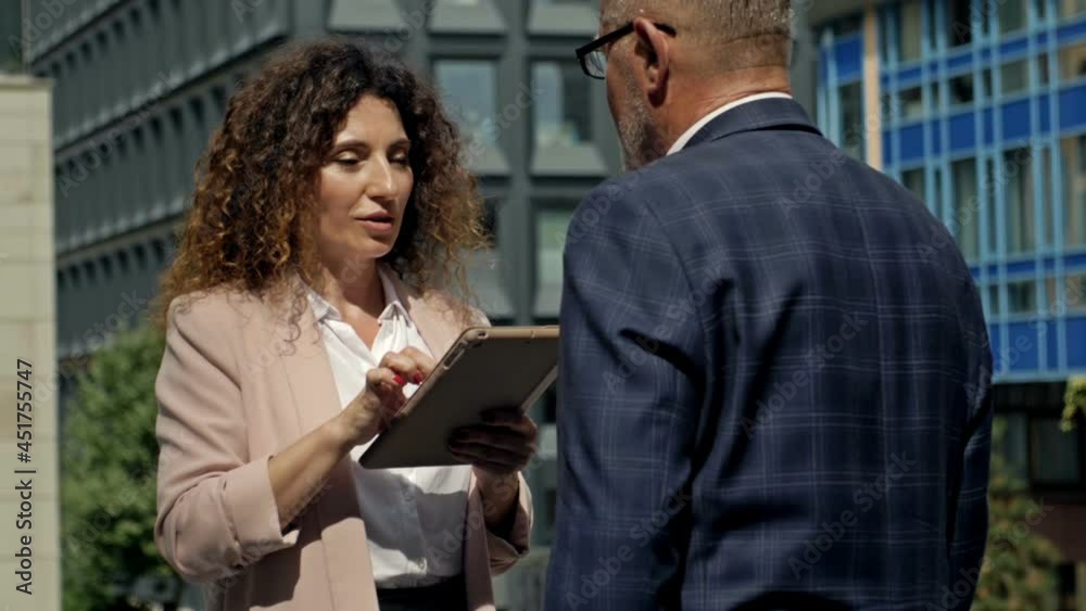 Business team man and woman working together outside. Boss and assistant holding tablet taking notes. Boss and secretary having consultation outdoor. Business team man and woman working together outside. Boss and assistant holding tablet taking notes. Boss and secretary having consultation outdoor.