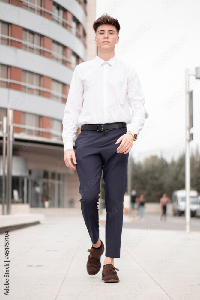 Chico joven empresario lleno de confianza caminando en un hotel con traje