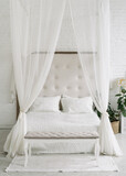White bedroom interior, closeup at canopy bed.