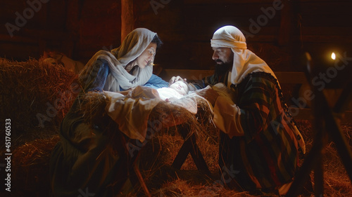 Canvas Print Mary and Joseph caressing baby Jesus in illuminated manger