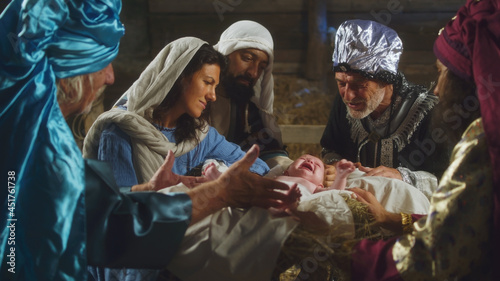 Canvas-taulu Magi and parents speaking over manger with baby Jesus