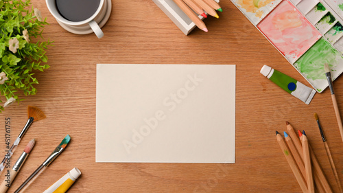 Creative art workspace  blank paper sheet for your project surrounded by painting tools
