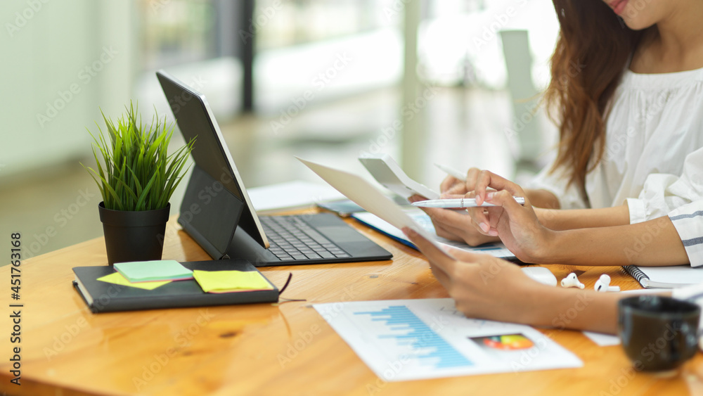 two hardworking business female worker looking business data on paperwork together two hardworking business female worker looking business data on paperwork together