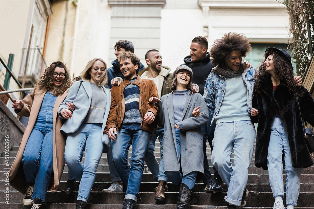 Obraz premium Happy diverse friends having fun walking around the city - Focus on center girl face