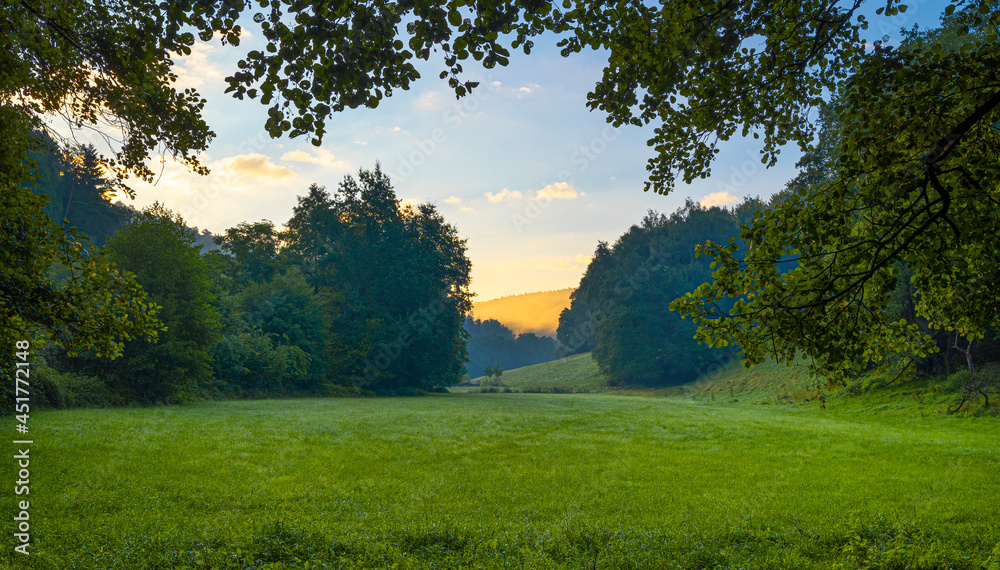 Sonnenaufgang über einer grünen Wiese Berglandschaft Sonnenaufgang über einer grünen Wiese Berglandschaft