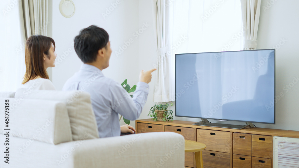 家でテレビを見る夫婦・カップル 家でテレビを見る夫婦・カップル
