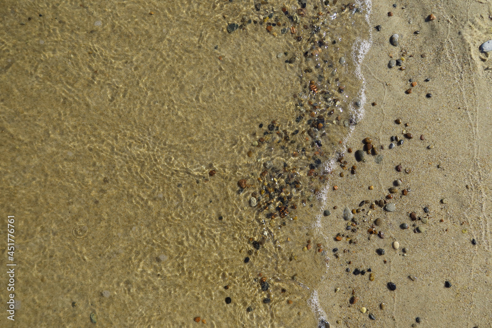 Soft sea wave on clean sandy beach. Abstract sand of beach and soft wave background. Top view Soft sea wave on clean sandy beach. Abstract sand of beach and soft wave background. Top view