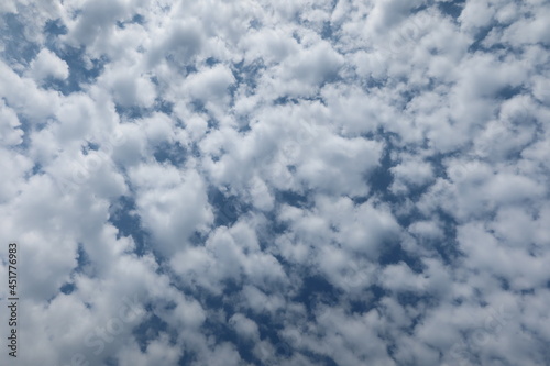 Altocumulus clouds. The sun shines through the Altocumulus clouds. Cloudscape with altocumulus clouds at sunny day photo