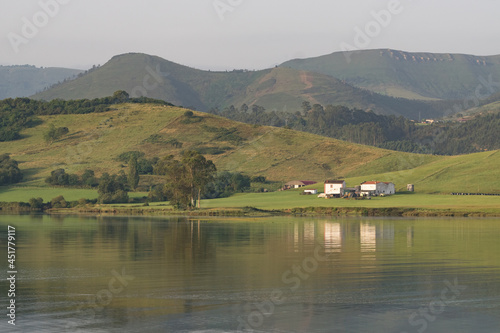 Reflection landscape of San Vicente de la Barquera marsh and ships and boats in a calm day, Cantabria, Spain