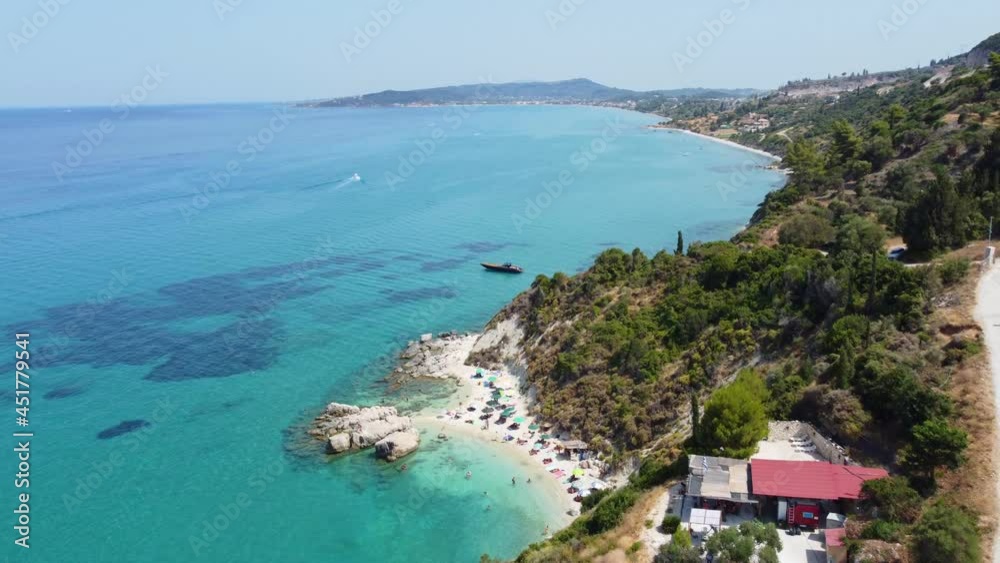 Tourists Enjoying Small Beach With Clear Blue Water In Summer - Scenic Beach At Zakynthos, Ionian Islands Of Greece. - aerial Tourists Enjoying Small Beach With Clear Blue Water In Summer - Scenic Beach At Zakynthos, Ionian Islands Of Greece. - aerial