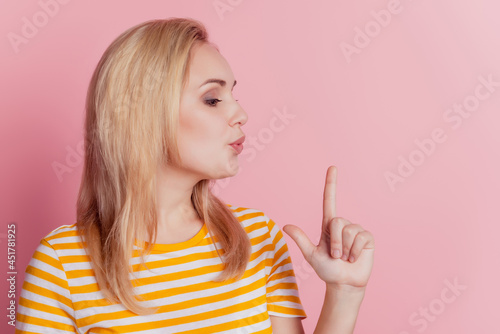 Portrait of stunning blonde girl hands make pistol gesture blow kiss on pink background