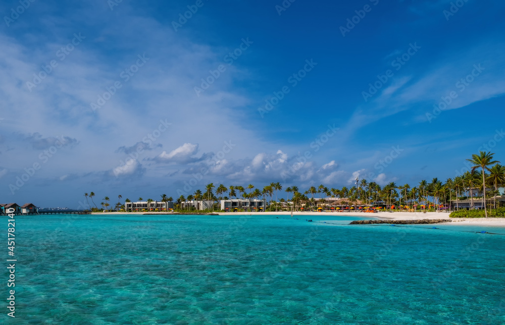 hard rock hotel buildings with palms against the background of emerald water. Crossroads Maldives, july 2021