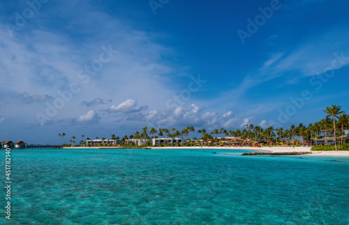 hard rock hotel buildings with palms against the background of emerald water. Crossroads Maldives, july 2021 © Сергій Вовк