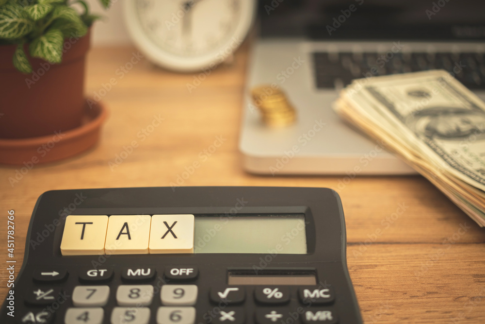 Calculating and paying TAX concept background. Business desktop with calculator, laptop and dollar bills. Business photo Calculating and paying TAX concept background. Business desktop with calculator, laptop and dollar bills. Business photo