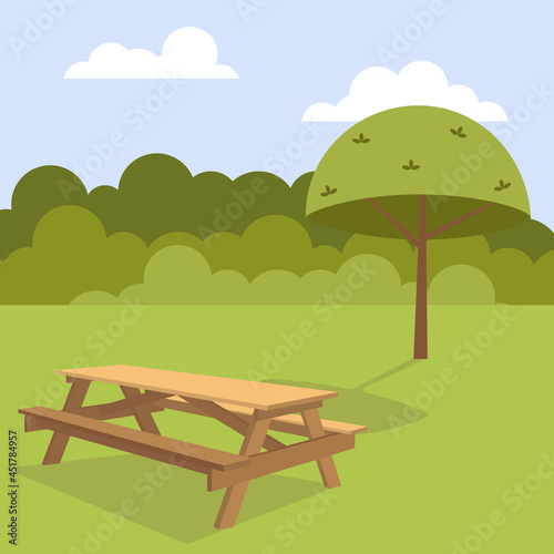 A table in a clearing in the forest. Picnic table in a clearing under a tree. Wooden table in the forest.